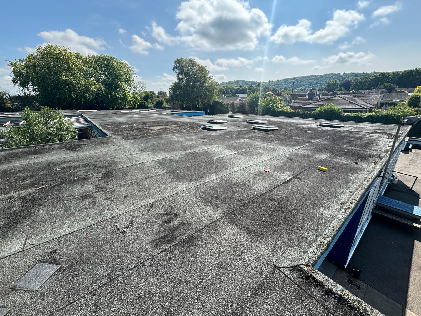 Existing flat roof at St Andrews School in Oxfordshire showing aged roofing membrane and rooflights prior to commercial roof refurbishment works.