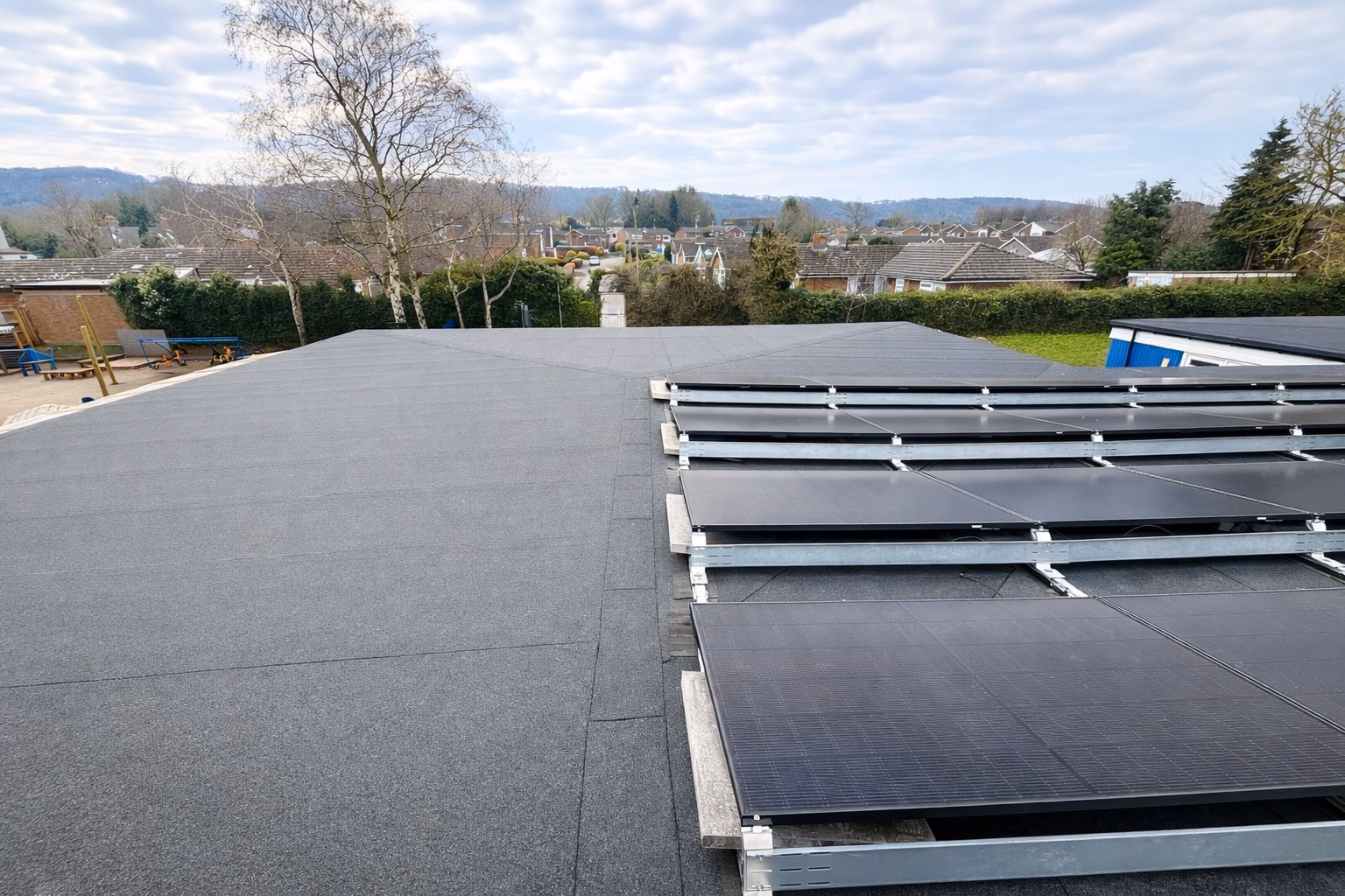 Commercial solar panels installed on a newly refurbished flat felt roof in the UK