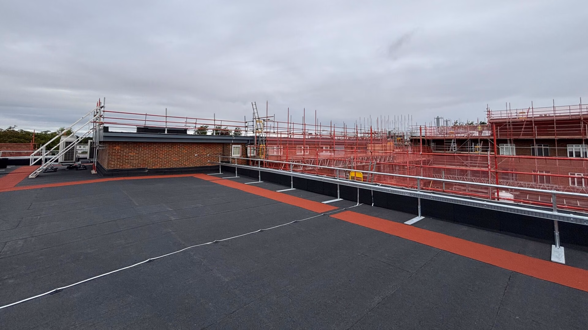 Completed commercial flat roof refurbishment at MRC Harwell Oxfordshire showing Langley roofing system, walkways and permanent guardrail installation.
