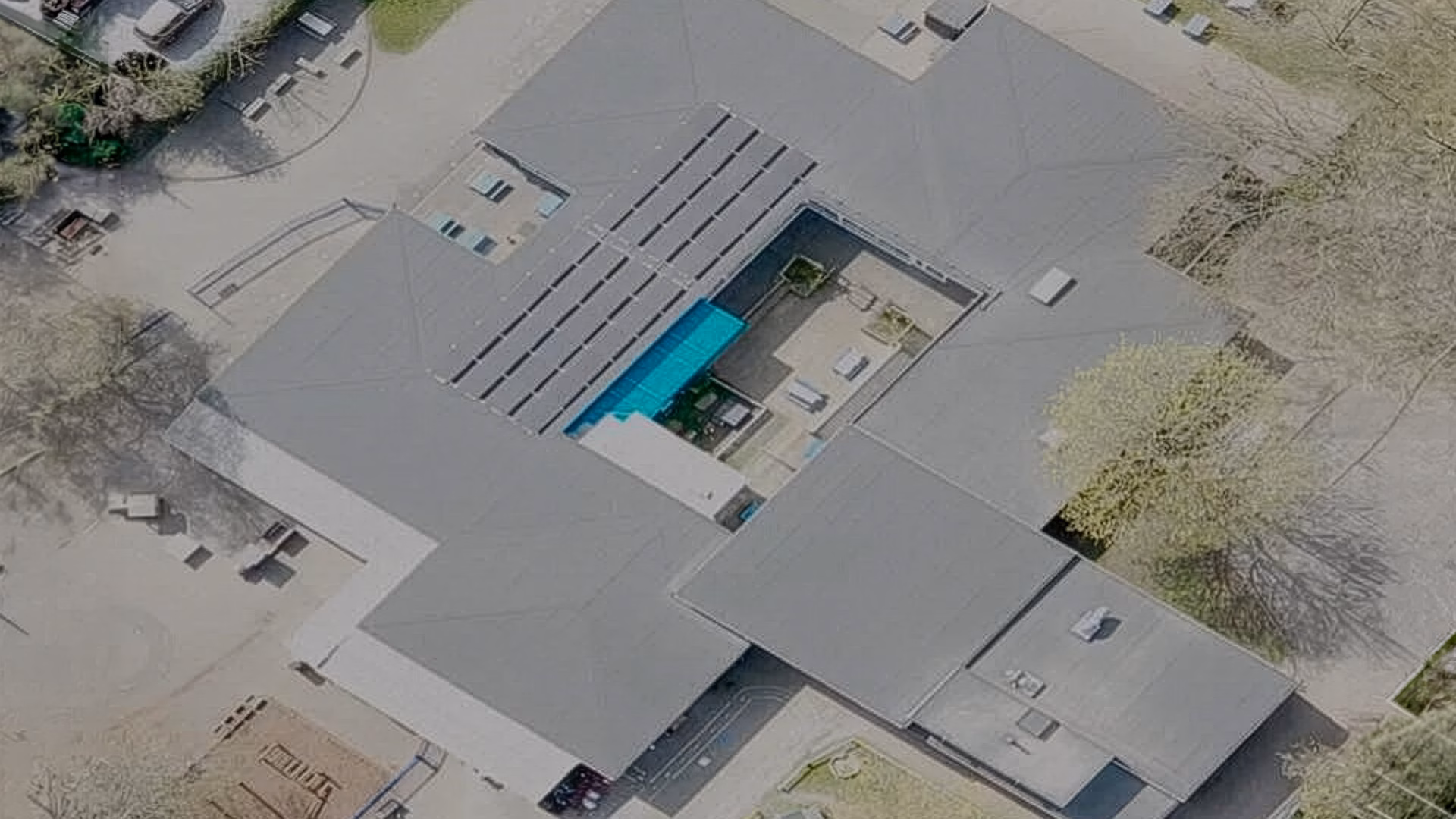 Aerial view of St Andrews School showing newly installed flat roof system and solar panels surrounding the central courtyard.